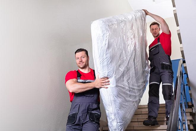 box spring being carried out of a cluttered bedroom in Birmingham